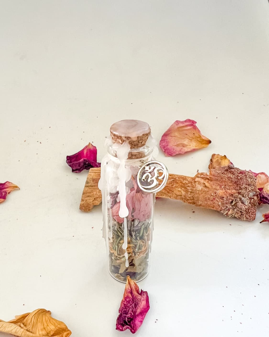 Frasco de hechizos con hierbas secas, flores y piedra amatista