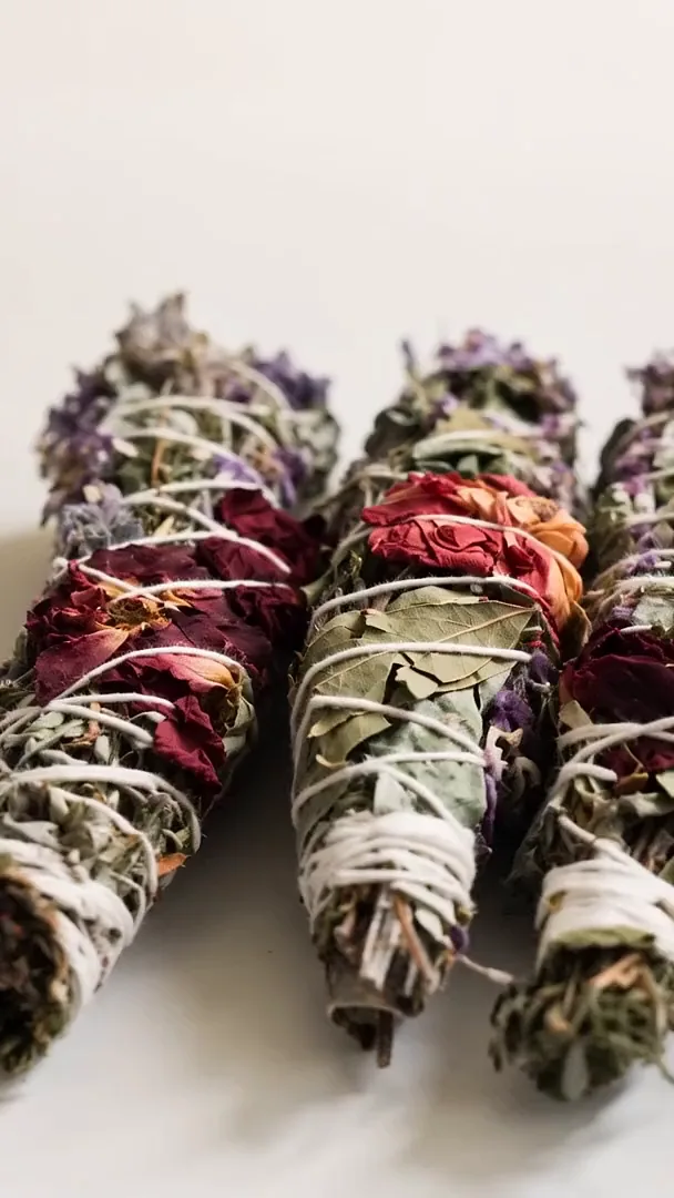 Cuatro sahumos de lavanda, romero y pétalos de rosa sobre un fondo blanco